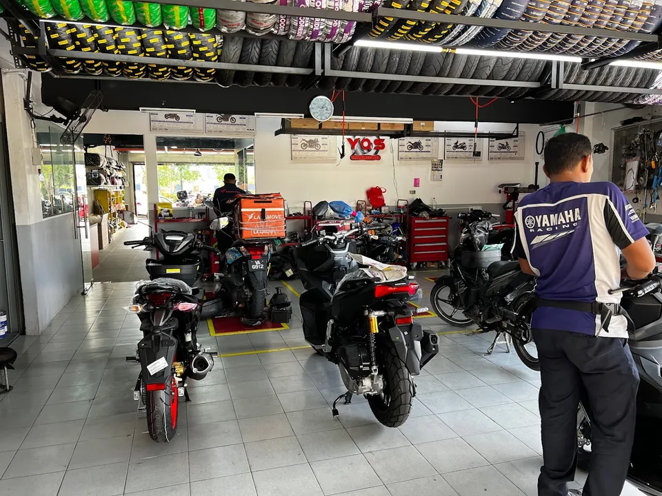 Motorcycle servicing inside the SGH Yamaha Quality Service workshop.